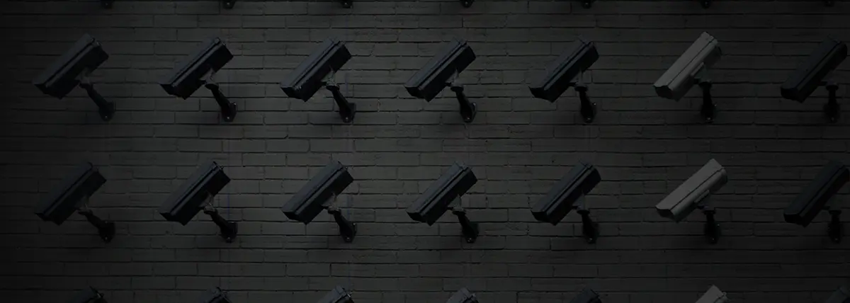 a wall of surveillance cameras looking down and to the viewer's left